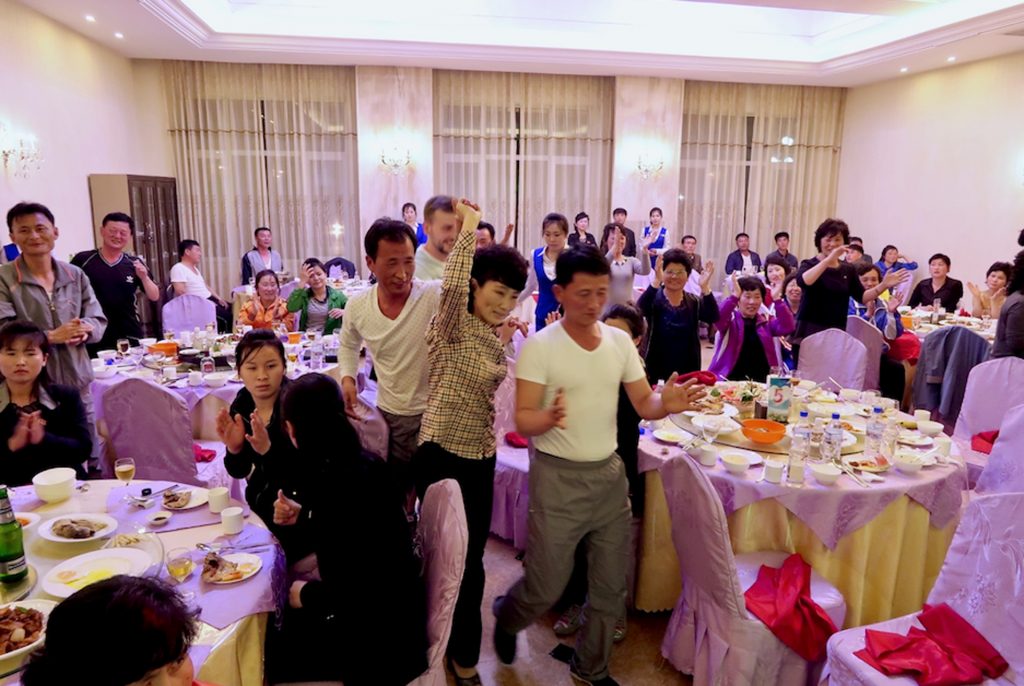 A group of foreigners and Koreans dance in a restaurant in Sinuiju.