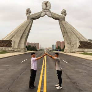 Two men imitate the pose of the Arch of Reunification on the Thongil Highway, just outside Pyongyang. -- Korean unification