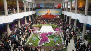 North Koreans gather at a floral arrangement in honour of Kim Il Sung on the Day of the Sun.