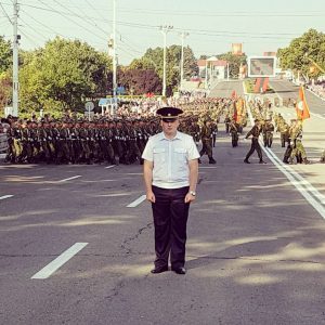 Festivals in Transnistria: a police officer stands guard as soldiers march behind him in Tiraspol, Transnistria.