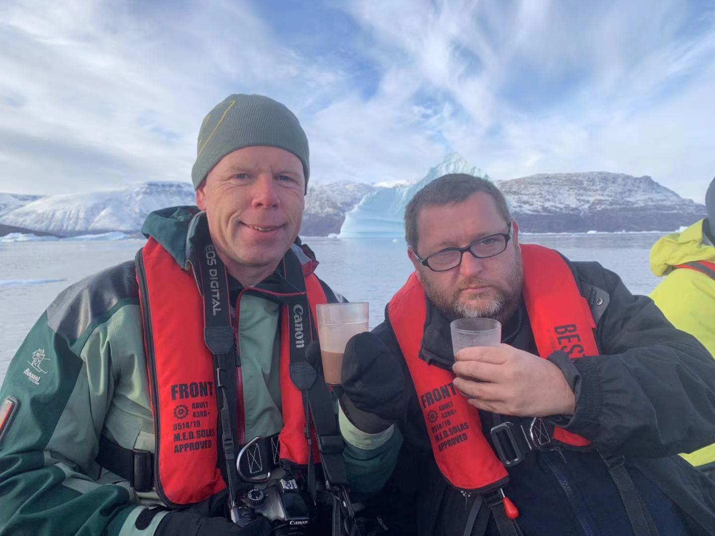 Two adventurers enjoy a beverage on their Greenland cruise.
