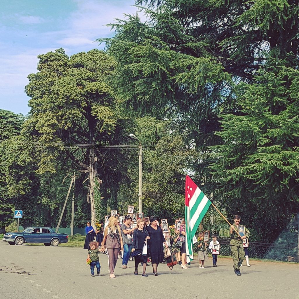 Locals walk proudly with an Abkhazian flag in Abkhazia.